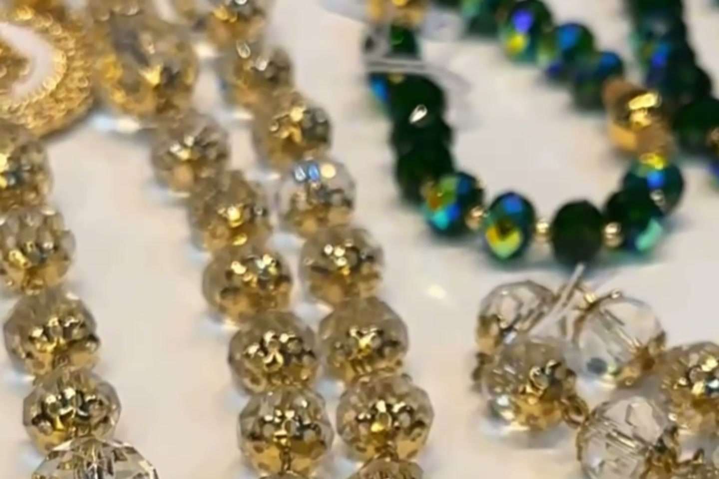 Terços de cristal com contas douradas sobre o balcão